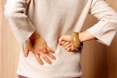 getty_rm_photo_of_woman_holding_back.jpg?resize=375px:250px&output-quality=50