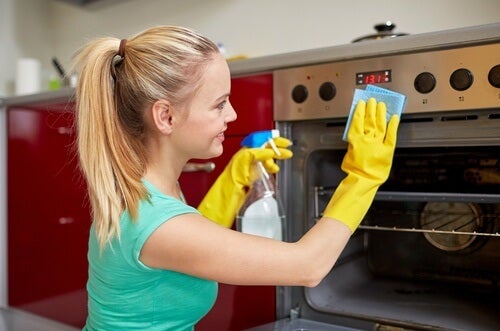 A woman cleaning the stove